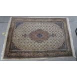 A CREAM GROUND TABRIZ RUG with a light terracotta medallion, matching borders and dark blue