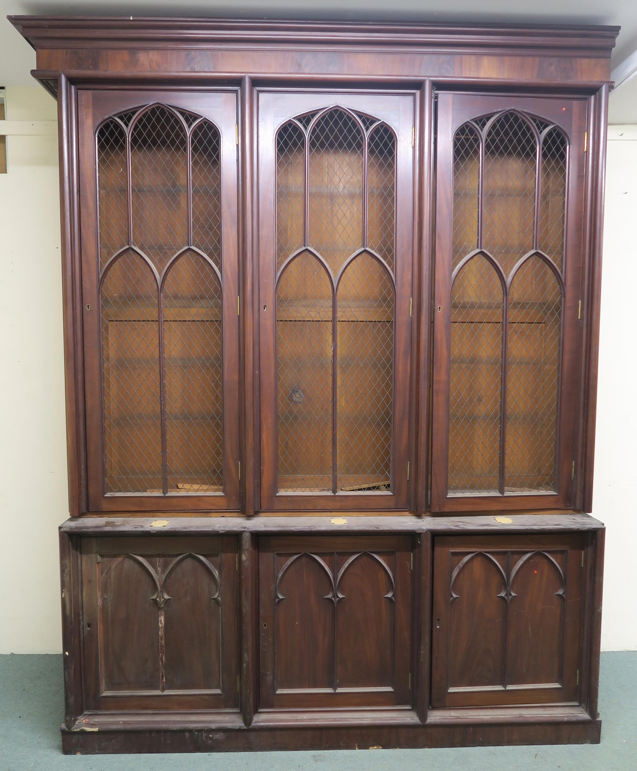 A VICTORIAN MAHOGANY GOTHIC REVIVAL BOOKCASE, with three pierced grill doors above three stylized