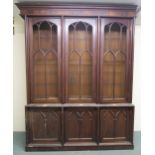 A VICTORIAN MAHOGANY GOTHIC REVIVAL BOOKCASE, with three pierced grill doors above three stylized