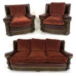 AN EARLY 20TH CENTURY OAK FRAMED THREE PIECE SUITE consisting three seater sofa 82cm high x 182cm