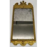 A GEORGIAN GILT WOOD AND GESSO WALL MIRROR carved with Prince of Wales feathers, flanked by