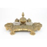 A FRENCH GILT METAL DESK STAND with two cushion shaped cut glass inkwells and a central lidded pot