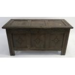 AN 18TH CENTURY OAK COFFER the hinged lid set with three panels above a carved foliate frieze and