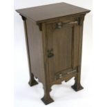 AN OAK ARTS AND CRAFTS BEDSIDE CABINET BY HENRY BARKER LTD NOTTINGHAM with panel door mounted with