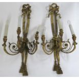 A PAIR OF GILTWOOD AND GESSO WALL SCONCES with ribbon tied tasseled frames, joined by three
