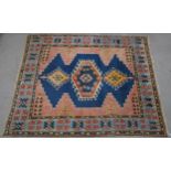 A PINK & BLUE GROUND TURKISH KAYAM RUG with floral geometric central medallion and multicoloured