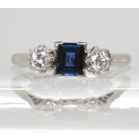 A platinum sapphire and diamond three stone ring, the square cut sapphire measures 5mm x 4.1mm x 2.