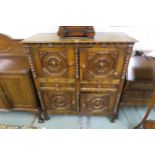 A 20th century stained oak Jacobean style cabinet with two doors above two drawers above two further