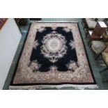 A black ground oriental style rug with floral central medallion and matching borders, 315cm long x