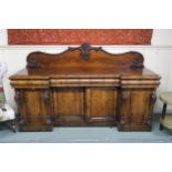 A Victorian mahogany inverted breakfront sideboard with three drawers above four cabinet doors