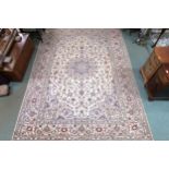 A cream ground fine Keshan rug with central medallion, matching spandrels and borders, 334cm long