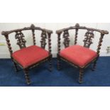 A pair of Victorian oak corner chairs extensively carved with barley twist supports and red