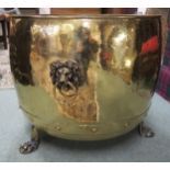 A rivetted brass log bin, on lion's paw feet and with mask handles Condition Report:Available upon