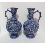 A pair of German blue glazed ewers with mask spouts Condition Report:Available upon request