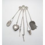 An Edwardian silver chatelaine, the cast art nouveau openwork waist clip in the form of a putto, the