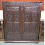 A late Victorian oak two door wardrobe with carved panel doors and sides, 168cm x 146cm x 45cm
