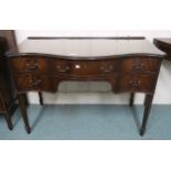 A 20th century mahogany serpentine front desk with single central drawer flanked by two drawers