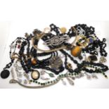 A jet locket and beads, black glass beads, a base metal fob chain, giant amber coloured plastic bead