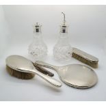 A three piece silver dressing table set with engine turned decoration, London 1944, and a pair of