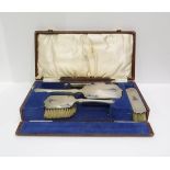 A cased George V silver four piece dressing set, in the art deco style, with engine turned