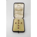 9ct gold garnet set cross, the bail stamped 9ct, in its own 'shaped to fit' fitted box, stamped