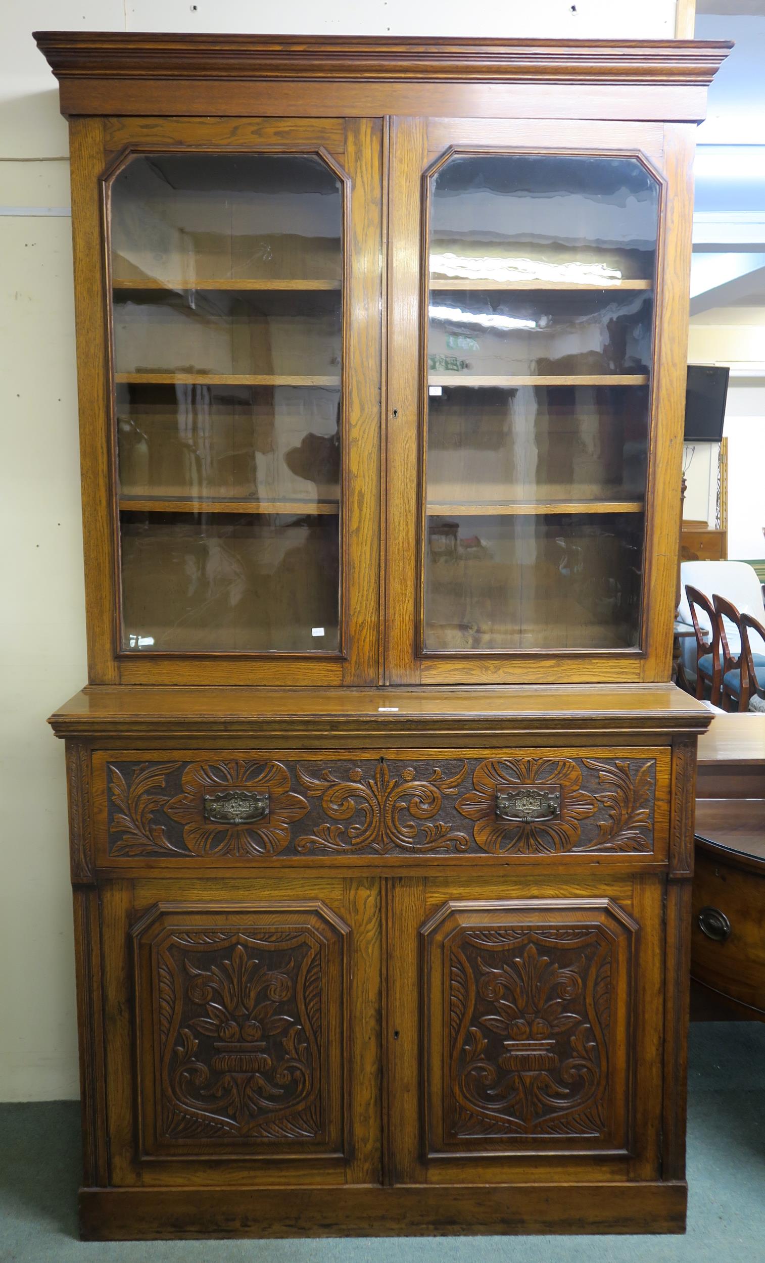 A Victorian oak secretaire bookcase with glazed two door bookcase above single drawer secretaire