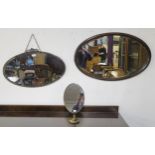 A 20th century brass framed oval bevelled glass wall mirror, oak framed oval bevelled glass wall