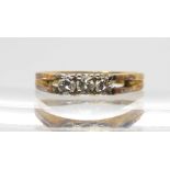 An 18ct gold three stone diamond ring set with estimated approx 0.25cts to the retro mount, size