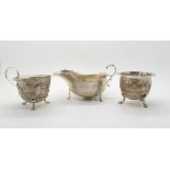 A silver Georgian style sauce boat with flying scroll handle and scalloped rim, by Martin, Hall &