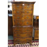 An early 20th century mahogany serpentine front chest on chest with two over three drawers above