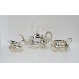 A three piece EPNS tea service, comprising tea pot, milk jug and sugar bowl, of shaped form with