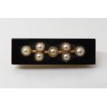 A mourning brooch set with onyx and pearl, and mounted in yellow metal. dimensions 3.2cm x 1cm,