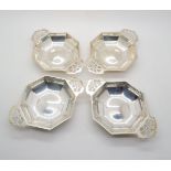 A set of four octagonal shaped bon bon dishes with pierced fretwork handles, by Robert Stewart,