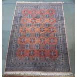 A terracotta ground Bokhara rug with all over design and cream borders, 260cm long x 184cm wide