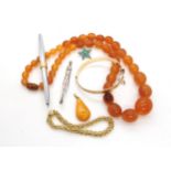 A Polish silver mounted amber pendant a string of yellow amber coloured beads, a turquoise star