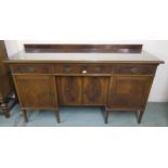 A 20th century mahogany sideboard with three drawers above four cabinet doors on square tapering