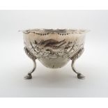 An Edwardian Irish silver sugar bowl, of circular form with repousse decoration of birds amongst
