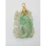 A Chinese green hardstone fish pendant, further carved with foliage and water lilies. the bright