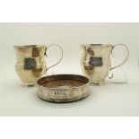 A pair of silver mugs, the bodies with a hammered finish and S shaped handles, and a silver wine