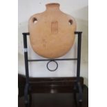 An Oriental terracotta flask on a contemporary wrought iron stand Condition Report:Available upon