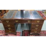 An early 20th century mahogany and burr walnut pedestal writing desk with central drawer flanked