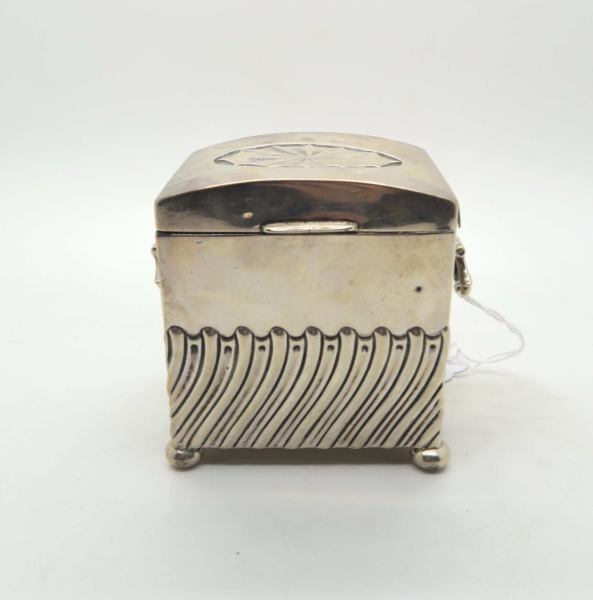 An Edwardian silver tea caddy, modelled as a chest, the body with waved fluted decoration, with