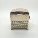 An Edwardian silver tea caddy, modelled as a chest, the body with waved fluted decoration, with
