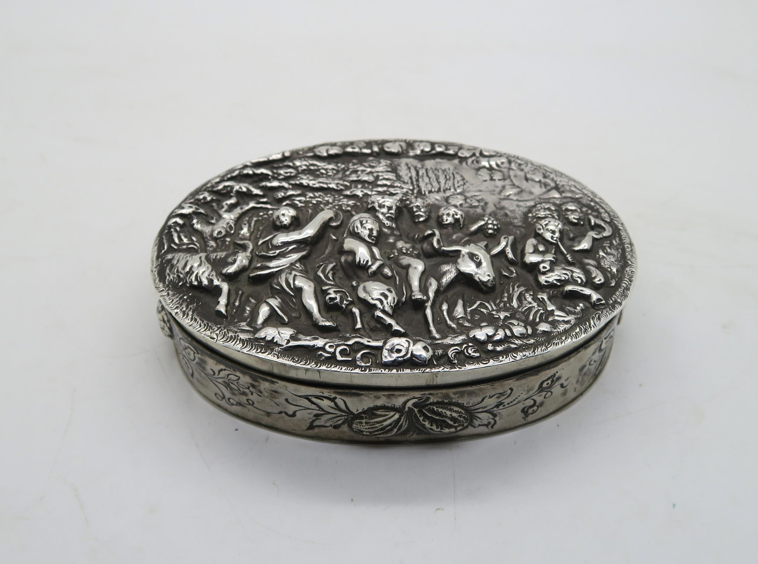 A Continental silver table box, with repousse and chased bacchanalian scenes to the lid, with