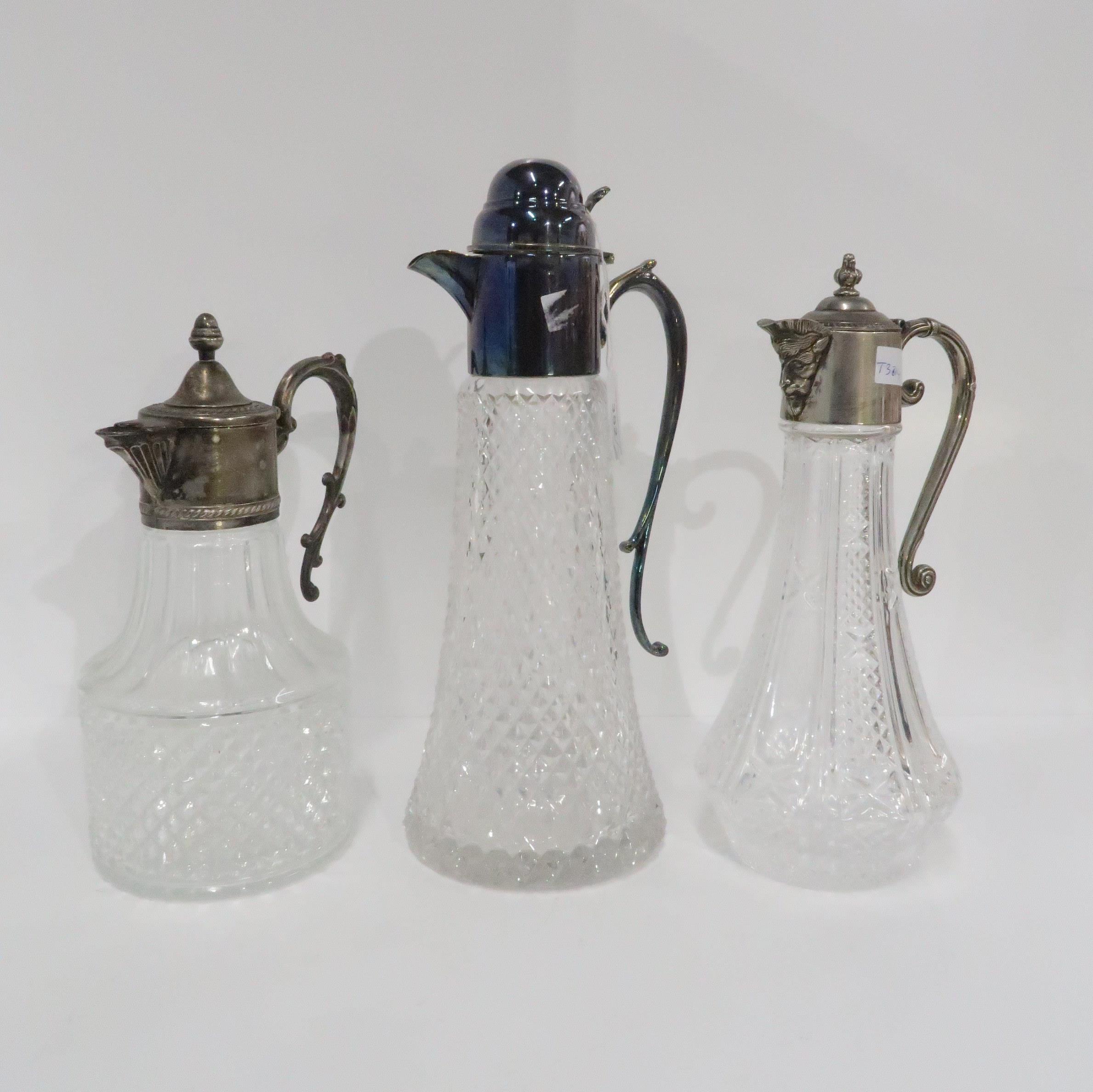 Three EPNS topped cut and moulded glass claret jugs, one with mask spouts (3) Condition Report: