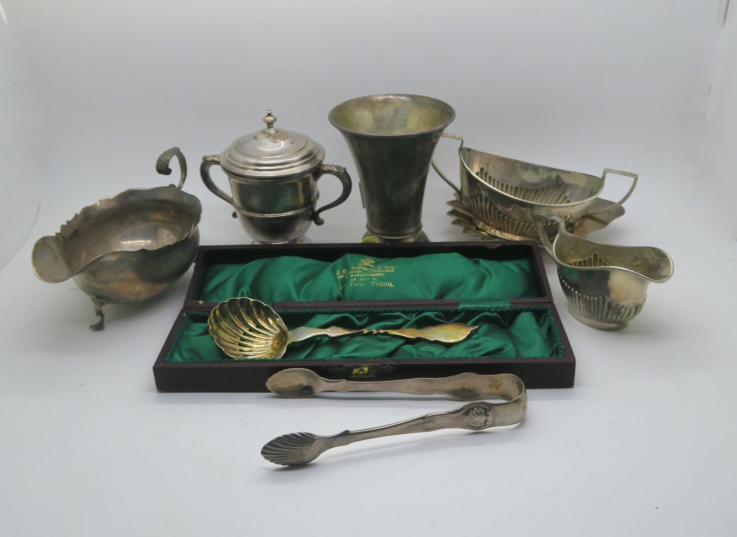 A collection of silver including a Georgian style silver sauce boat with flying scroll handle, by