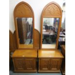 A pair of 20th century teak two door bedside cabinets with mirror backs in a gothic style and a