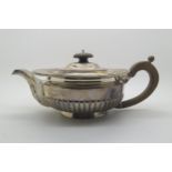An Edwardian silver teapot, of squat circular form, the body half fluted, with acanthus leaf