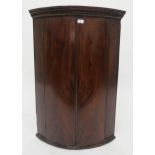 A Victorian mahogany dome front hanging corner cabinet with three shelved velvet lined interior