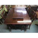 A Victorian mahogany extending dining table on turned supports and six mahogany scroll back dining